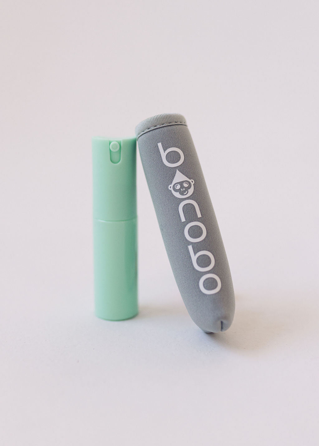 Gray neoprene pouch with mint green 20ml spritzer bottle, close-up of texture and nozzle.