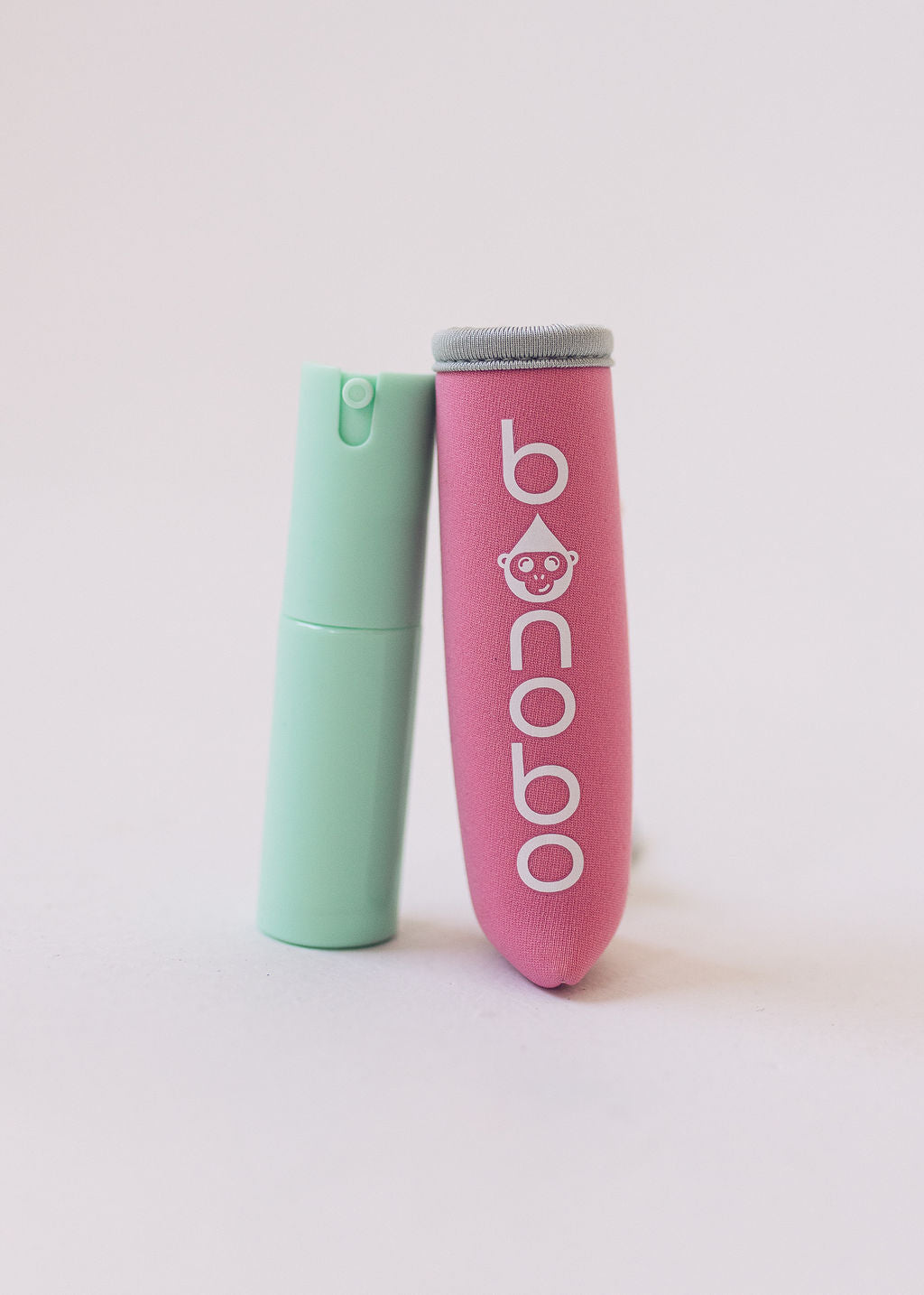 Variant shot showing the pouch and bottle in pink and grey configuration with elastic band and bottle nozzle visible for color selection clarity.