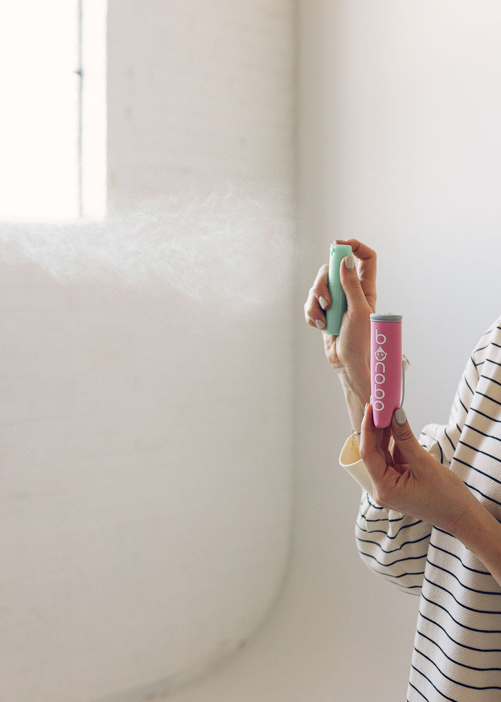 Lifestyle image of the spritzer pouch and bottle tucked inside a diaper bag pocket, illustrating compact size and travel-friendly carrying.