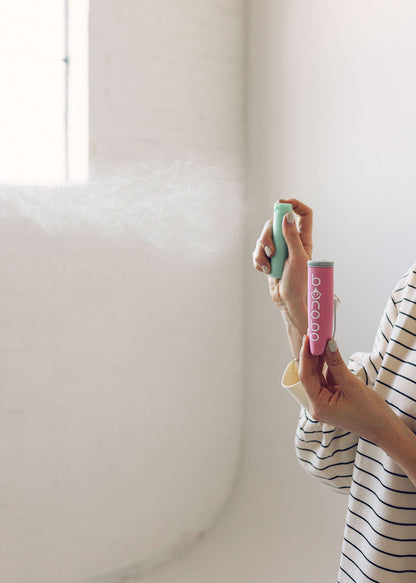 Lifestyle image of the spritzer pouch and bottle tucked inside a diaper bag pocket, illustrating compact size and travel-friendly carrying.