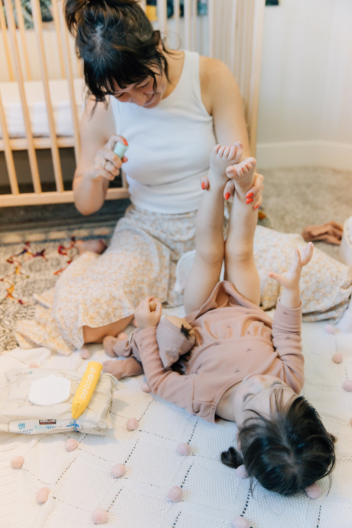 Spraying water before wiping during a diaper change