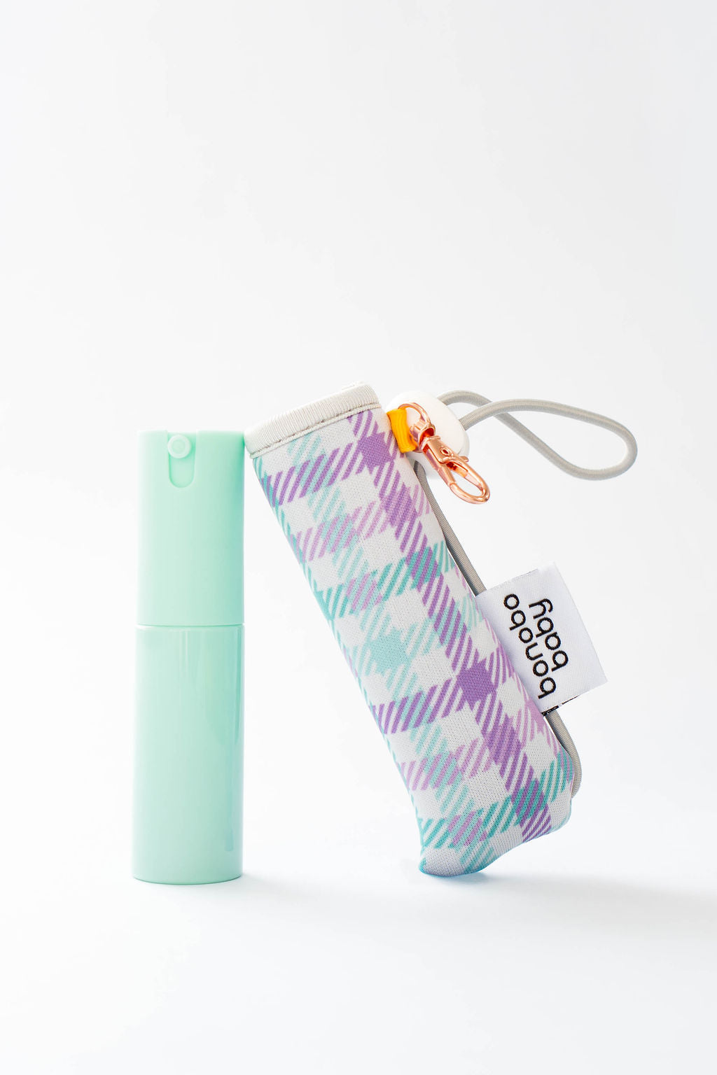 Mint green lip balm and plaid case with a clip on a white background