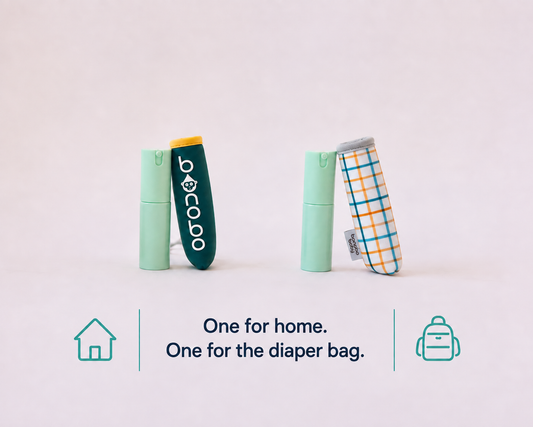 Two small baby bidets, one mint green and one harvest gingham standing upright on a white background with text below reading 'One for home. One for the diaper bag.